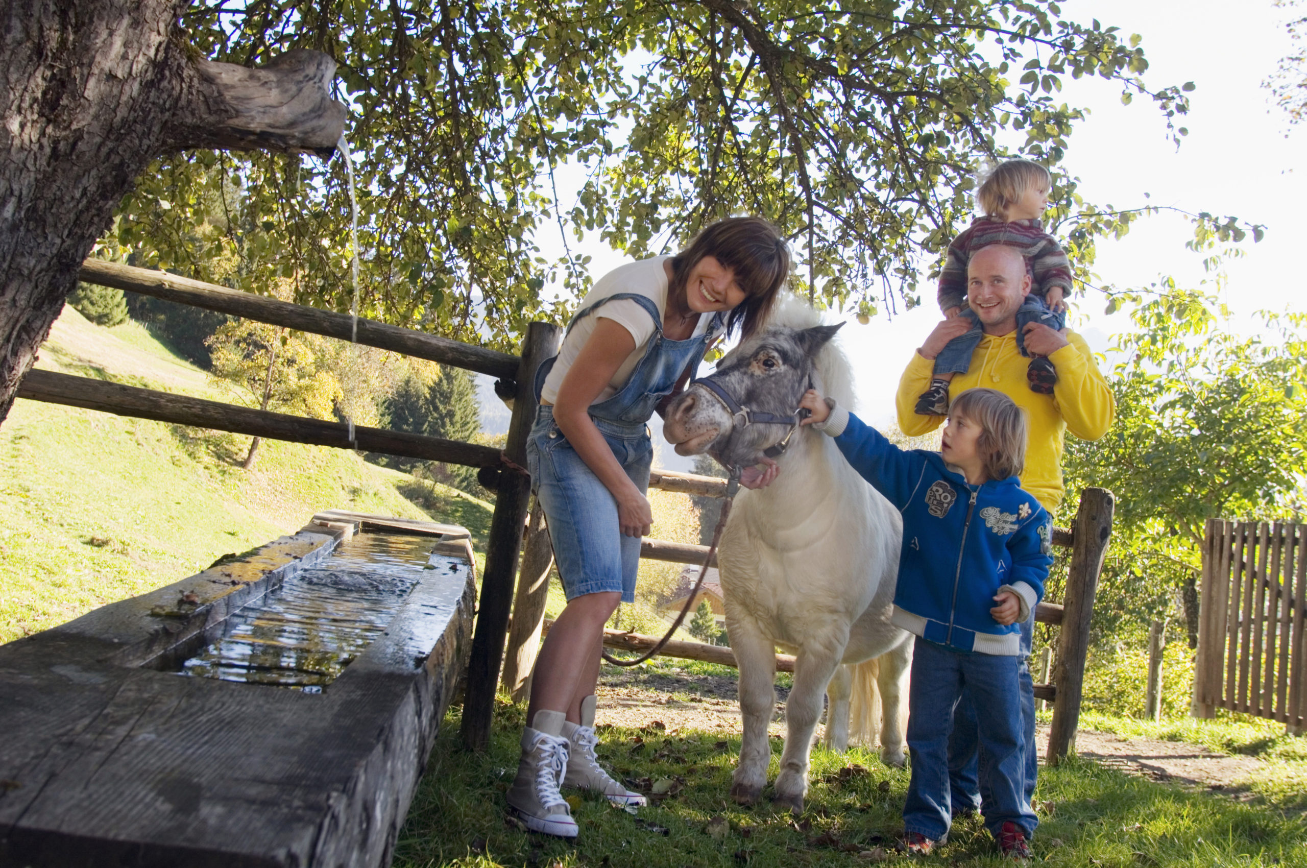 Familie mit Pony durch Brunnen